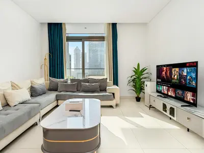 a living room with a couch and a flat screen tv at Burj Crown Luxury 2BR W Balcony & Pool View 8th Floor in Dubai