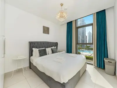 a bedroom with a large bed and a large window at Burj Crown Luxury 2BR W Balcony & Pool View 8th Floor in Dubai