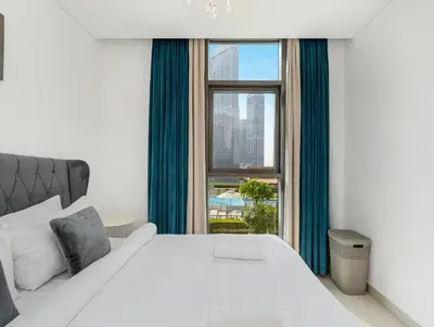 a bedroom with a large bed and a window at Burj Crown Luxury 2BR W Balcony & Pool View 8th Floor in Dubai