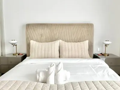 a bedroom with a white bed with two white socks at Elegant & Luxurious 1BR Apartment in Beach Isle in Dubai