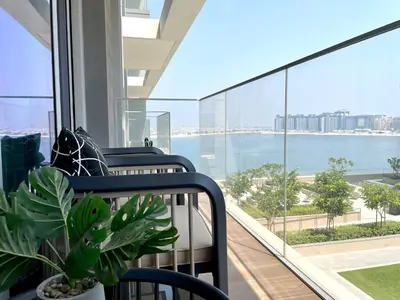 a balcony with chairs and a view of the water at Elegant & Luxurious 1BR Apartment in Beach Isle in Dubai