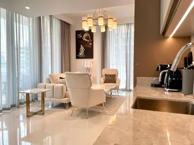 a kitchen and living room with chairs and a sink at Elegant & Luxurious 1BR Apartment in Beach Isle in Dubai