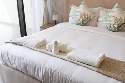a bed with two towels and two dolls on it at Trendy Studio Apartment in Binghatti Crystals in Dubai