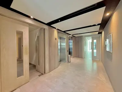 an empty hallway of a building with glass doors at Vserve -Elegant Penthouse Stay in the Heart of JVC in Dubai
