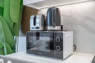 a coffee maker sitting on top of a microwave at Golden Stays - Binghatti Onyx I Brand New 1BR I Modern and Fully Furnished in Dubai