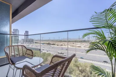 a balcony with chairs and a view of a highway at Golden Stays - Binghatti Onyx I Brand New 1BR I Modern and Fully Furnished in Dubai