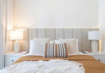 a bedroom with a large bed with two lamps at Luxury 2 BR Missoni Building Canal & Pool View in Dubai