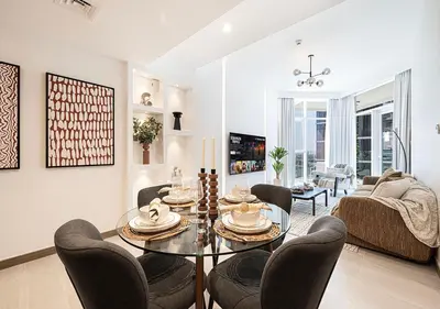 a living room with a dining room table and chairs at Luxury 2 BR Missoni Building Canal & Pool View in Dubai