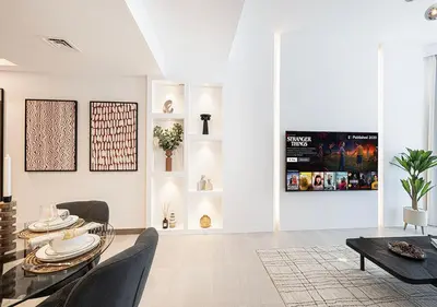 a living room with a table and chairs and a tv at Luxury 2 BR Missoni Building Canal & Pool View in Dubai