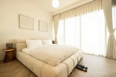 a large bed in a room with a large window at Seraya Residence 5 - 4BDR - Burj Views - Private Jacuzzi in Dubai