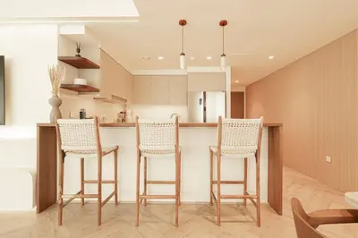 a kitchen with a bar with four chairs and a table at Seraya Residence 5 - 4BDR - Burj Views - Private Jacuzzi in Dubai
