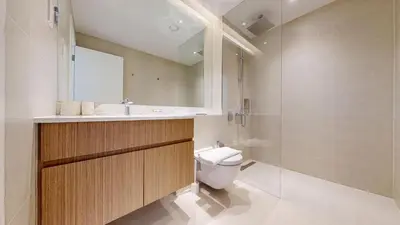 a bathroom with a toilet and a sink and a mirror at La Sirene 2 - Magnificient Two Bedroom in La Mer in Dubai