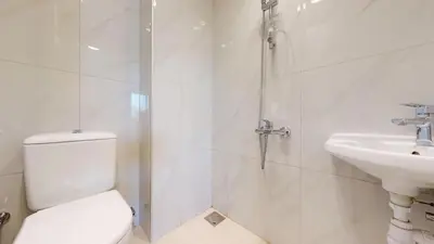 a white bathroom with a toilet and a sink at Elegant - Three Bed Villa in Jumeirah Golf Estate in Dubai