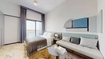 a hotel room with a bed and a couch at Mag Eye 920 - Spacious Studio in Meydan in Dubai