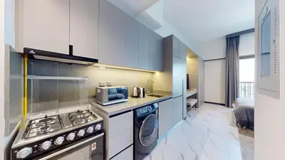 a kitchen with a stove and a microwave at Mag Eye 920 - Spacious Studio in Meydan in Dubai