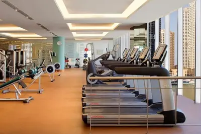 a gym with a row of tread machines at Stunning One Bedroom in the Marina in Dubai