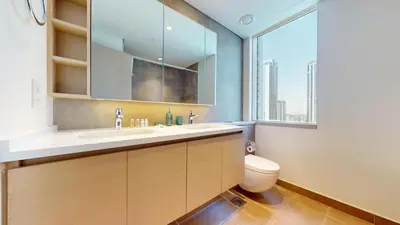 a bathroom with a toilet and a sink and a window at Creek Gate - Spacious Two Bed in Creek Harbour in Dubai