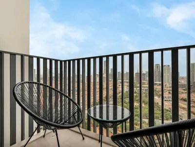 a balcony with two chairs and a table at NEW Luxury 2 Bed in Belgravia Heights in JVC in Dubai