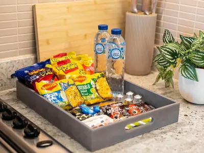 a tray filled with snacks and water bottles on a counter at The Dubai Mall Suite Luxury 1-Bed Near Burj Khalifa in Dubai