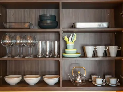 a shelf filled with dishes and bowls and glasses at The Dubai Mall Suite Luxury 1-Bed Near Burj Khalifa in Dubai