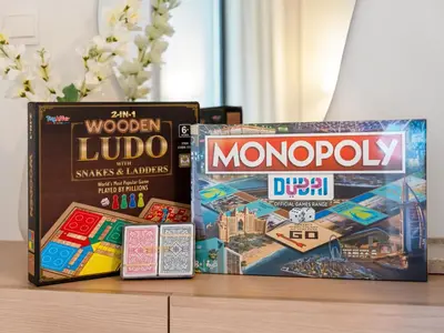 two board games and a monopoly on a table at The Dubai Mall Suite Luxury 1-Bed Near Burj Khalifa in Dubai