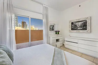 a bedroom with a bed and a large window at Luxury 2BR Haven with Expansive Terrace and Elegance in Dubai