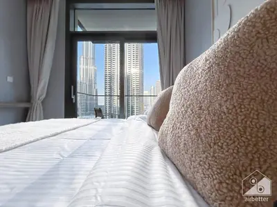 a bedroom with a bed with a view of a city at Luxury 4BR Apartment at Burj Crown I Balcony Views in Dubai