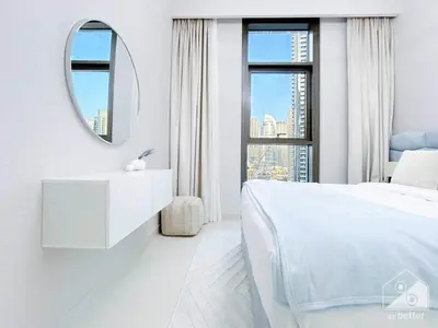 a white bedroom with a white bed and a mirror at Luxury 4BR Apartment at Burj Crown I Balcony Views in Dubai