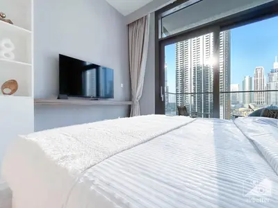 a bedroom with a white bed and a large window at Luxury 4BR Apartment at Burj Crown I Balcony Views in Dubai