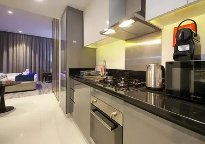 a kitchen with a stove top oven next to a room at Elegant Studio in Business bay Near Dubai Mall in Dubai