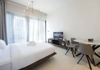 a bedroom with a bed and a table and a television at Elegant Studio in Binghatti Canal Near Dubai Mall in Dubai