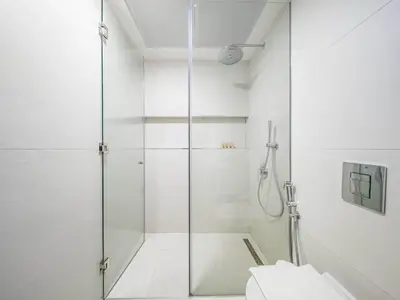 a glass shower in a bathroom with a toilet at TRPS - Luma 22, Jumeirah Village Circle - Chic 1BR Modern Sanctuary in Dubai