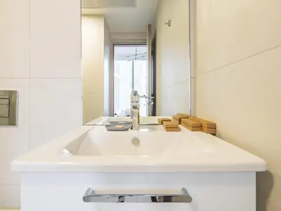 a white sink in a bathroom with a mirror at TRPS - Luma 22, Jumeirah Village Circle - Chic 1BR Modern Sanctuary in Dubai