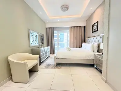 a bedroom with a bed and a chair at Premium Stay - Damac Heights 1BR in Dubai