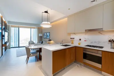 a kitchen with white countertops and a dining room at Address Residences, Dubai Opera 1, Downtown - Mint Stay in Dubai
