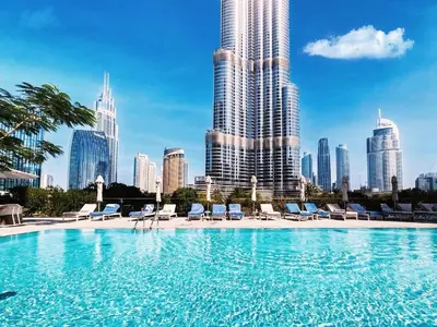 a large swimming pool with chairs and a city skyline at Address Residences, Dubai Opera 1, Downtown - Mint Stay in Dubai