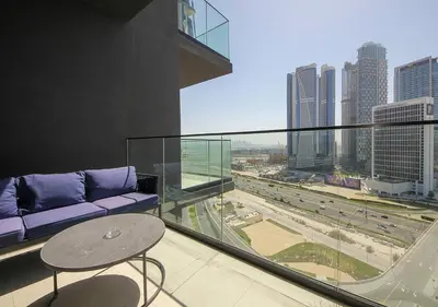 a balcony with a couch and a table and a city at Chic Studio Apartment Binghatti Canal Business Bay in Dubai