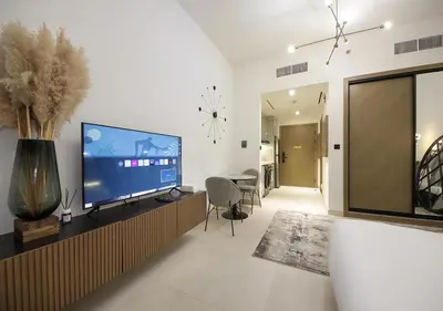a living room with a large flat screen tv at Chic Studio Apartment Binghatti Canal Business Bay in Dubai