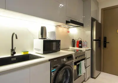 a kitchen with a washing machine and a sink at Chic Studio Apartment Binghatti Canal Business Bay in Dubai
