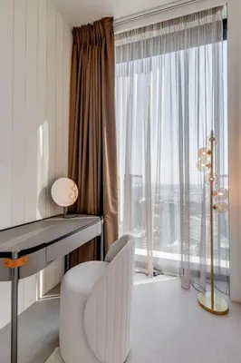 a white desk and a chair in a room with a window at ADDRESS Residences by Happy Season in Dubai