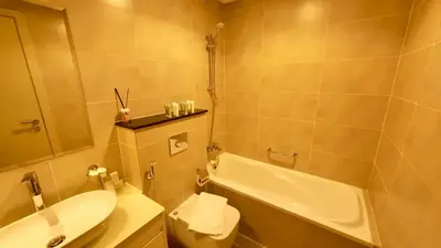 a bathroom with a toilet and a sink and a tub at Cosy Studio in Carson Tower C in Dubai