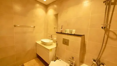 a bathroom with a toilet and a sink and a shower at Cosy Studio in Carson Tower C in Dubai