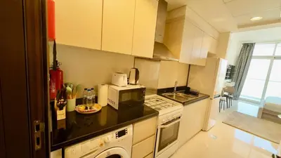 a small kitchen with a microwave and a stove at Cosy Studio in Carson Tower C in Dubai