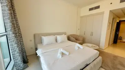 a bedroom with a white bed with towels on it at Cosy Studio in Carson Tower C in Dubai