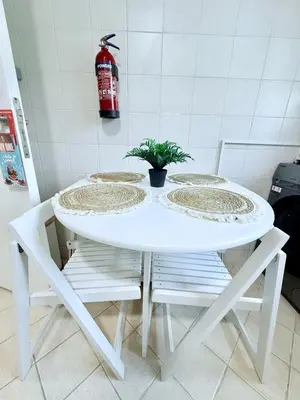 a white table with two chairs and a plant on it at LivWithUs-Studio in One BR Setup, Dubai Marina in Dubai