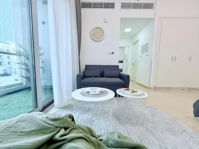 a living room with a couch and a table at LivWithUs-Studio in One BR Setup, Dubai Marina in Dubai
