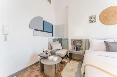 a bedroom with a bed and a table and a chair at Studio with Glimpse of Burj Khalifa, Minutes from Downtown Dubai, MAG 930, Mohammad Bin Rashid City by Deluxe Holiday Homes in Dubai