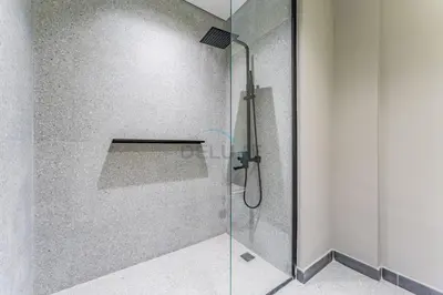 a shower with a glass door in a bathroom at Studio with Glimpse of Burj Khalifa, Minutes from Downtown Dubai, MAG 930, Mohammad Bin Rashid City by Deluxe Holiday Homes in Dubai