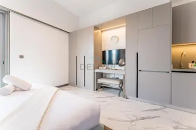 a bedroom with a white bed and a desk at Studio with Glimpse of Burj Khalifa, Minutes from Downtown Dubai, MAG 930, Mohammad Bin Rashid City by Deluxe Holiday Homes in Dubai