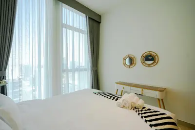 a bedroom with a white bed and a large window at Bright 1BR in Binghatti House, Prime Location in Dubai